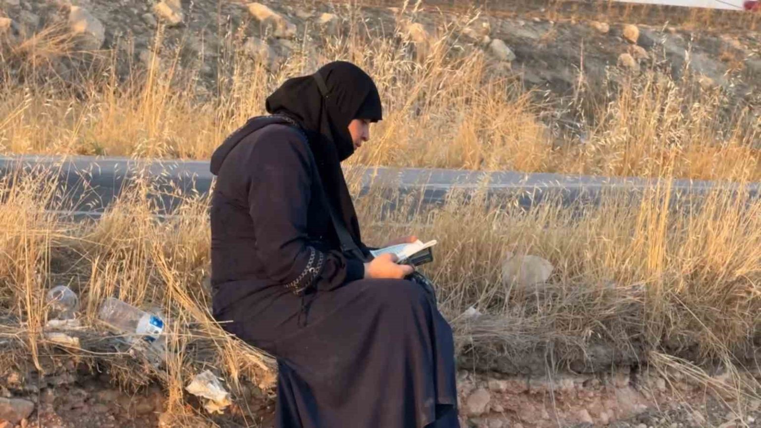 ters-donen-aractan-cikan-kadin-oturup-kurani-kerim-okudu