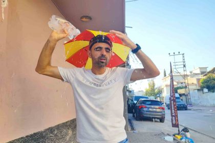 asiri-sicaklar-nedeniyle-kafasina-taktigi-semsiye-ile-geziyor