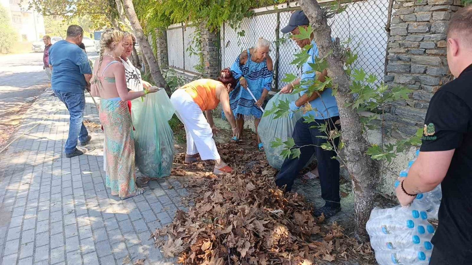 turistler-yangin-sonrasi-otel-cevresindeki-kurumus-ot-ve-yapraklari-temizledi